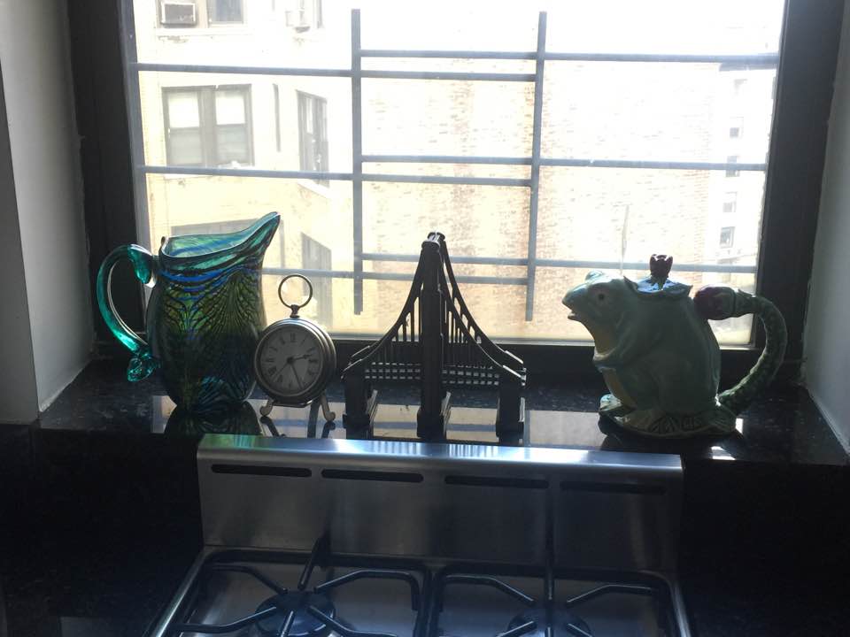 Our kitchen sill has a pitcher from Laguna Beach, a clock from Austin, a bridge from San Francisco (gifted in Austin) and a froggy teapot from Orange County.
