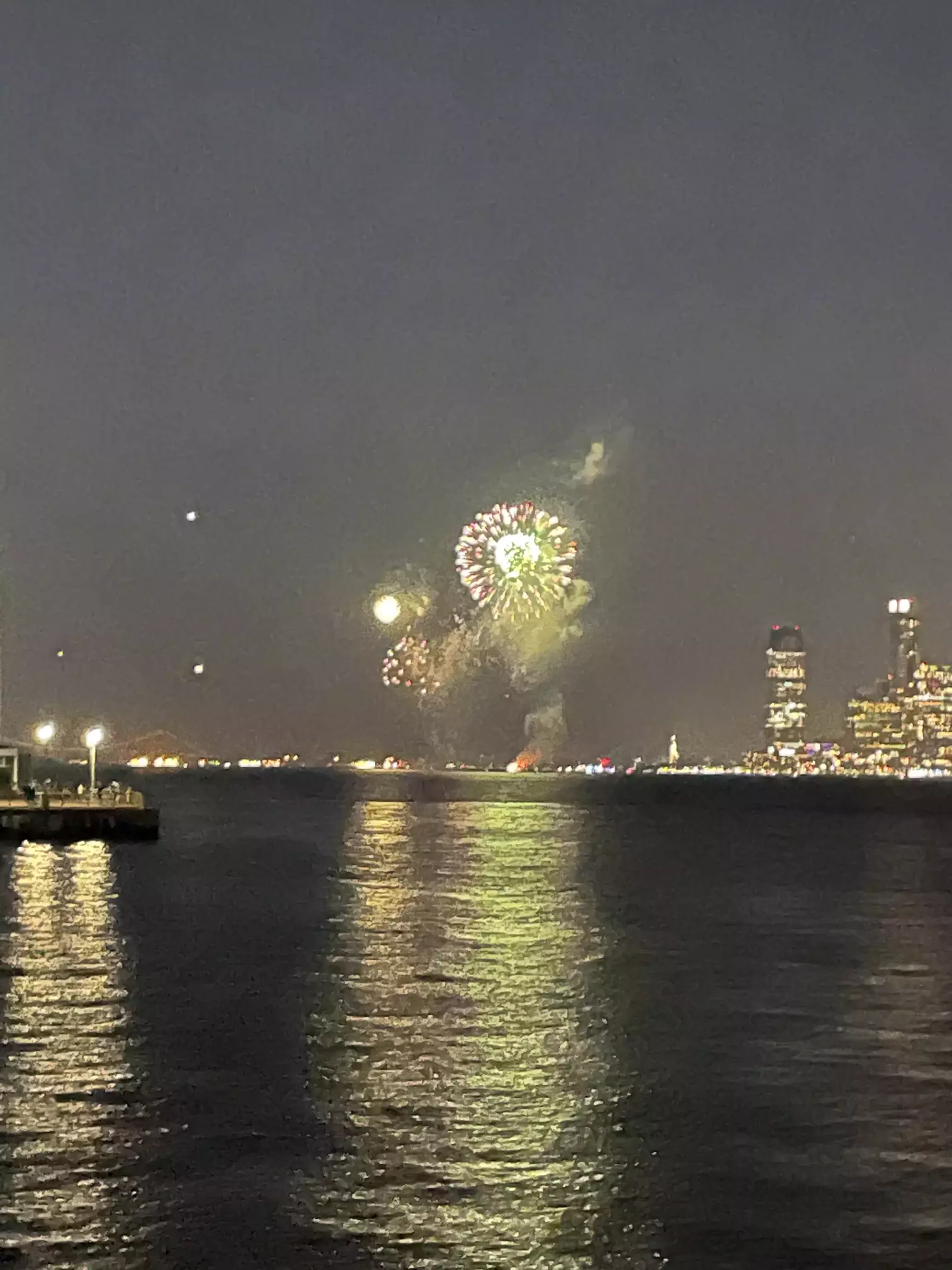 Jersey city fireworks as seen from Manhattan looking southwest, with the Statue of Liberty on the right
